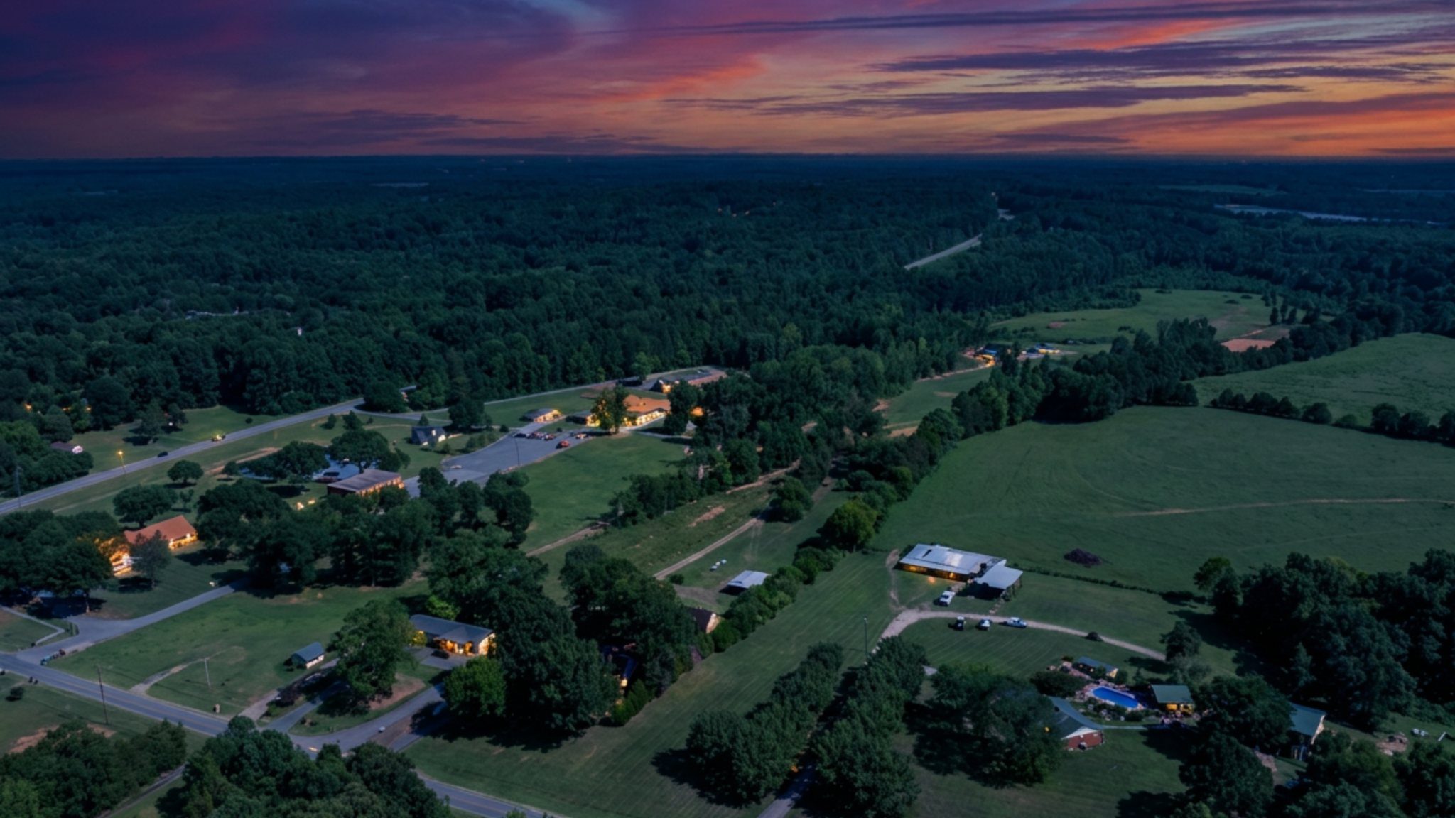 Aerial view of improvements, pasture and surrounding roads at dusk