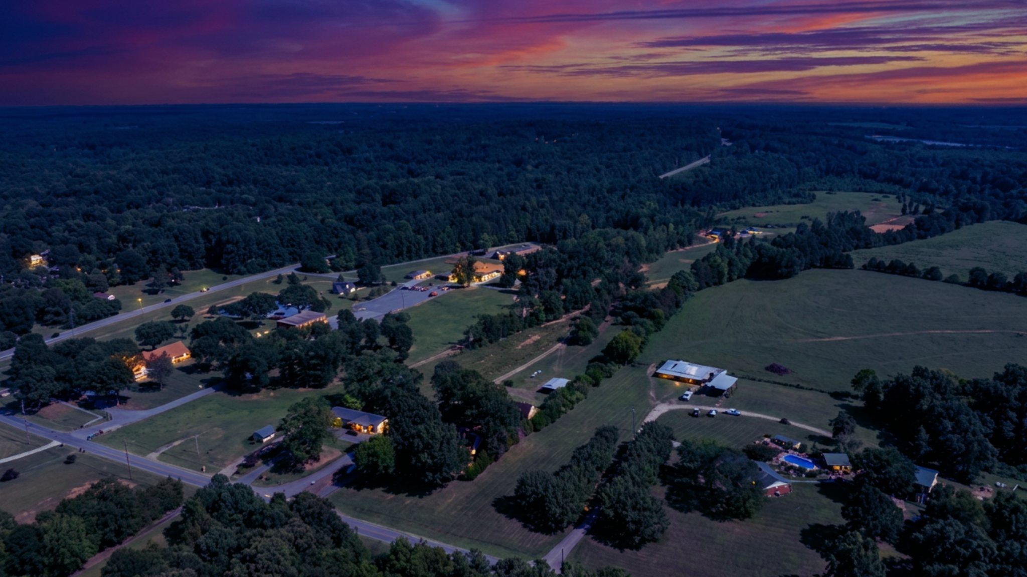 Dusk aerial over homestead, barns and open pasture