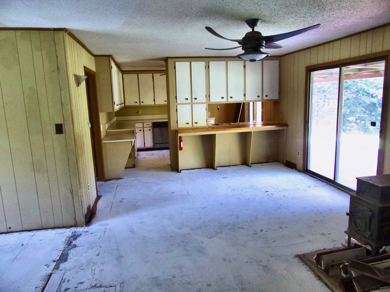 2555 residence — kitchen with wood stove and sliding-door access