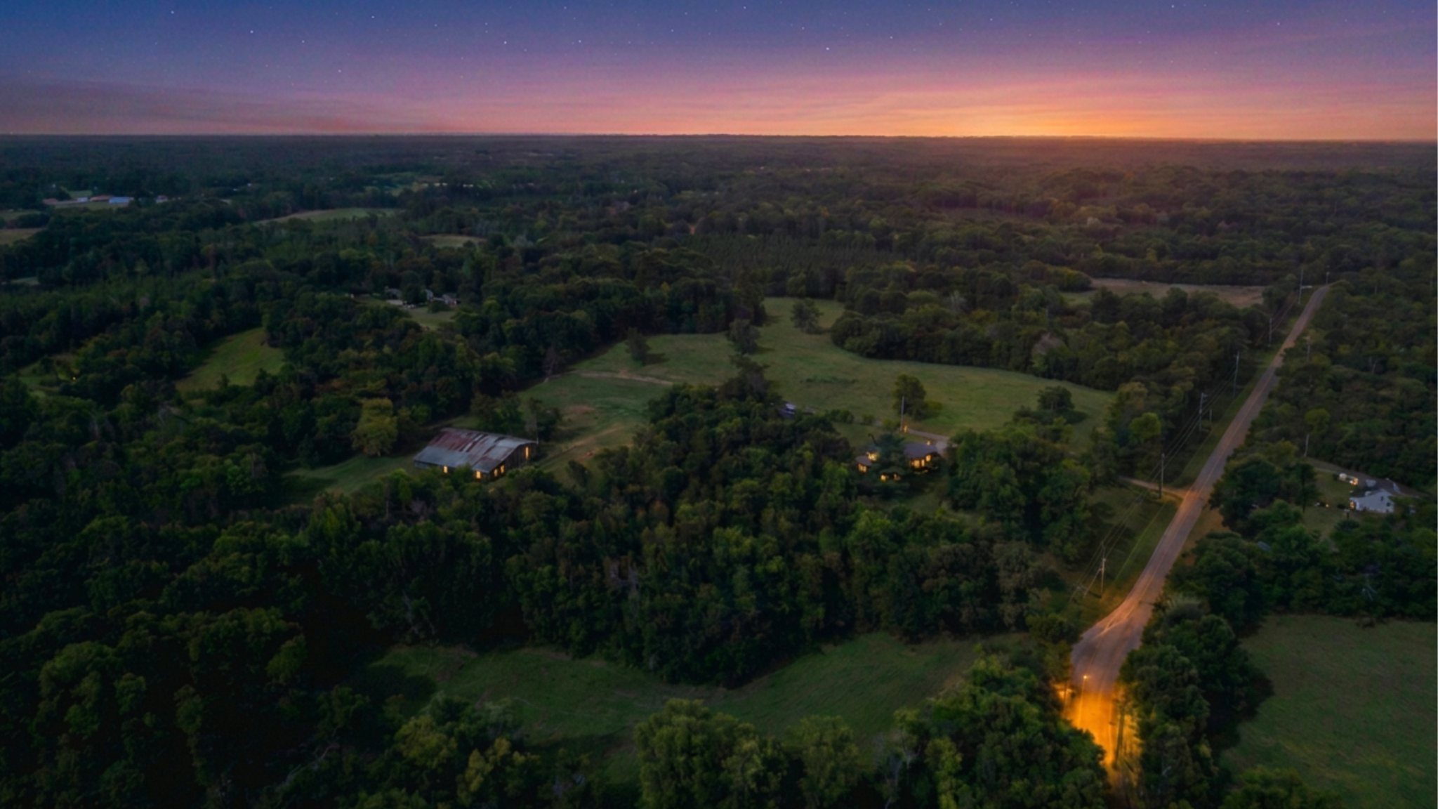 Sunset aerial over river corridor and open fields